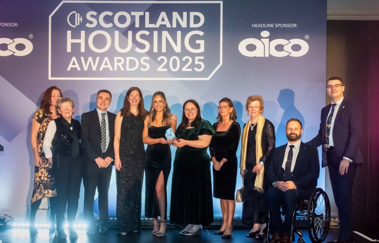 The Hospital Housing Clinic team on stage at the Scotland Housing Awards 2025 holding their trophy